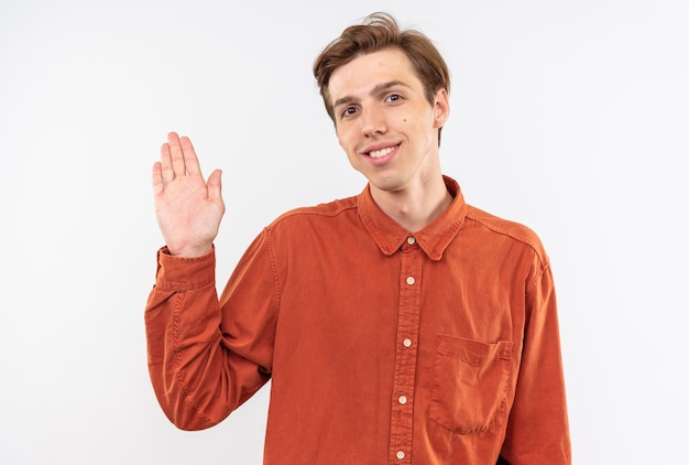 Jovem bonito sorridente usando uma camisa vermelha e fazendo um gesto de olá