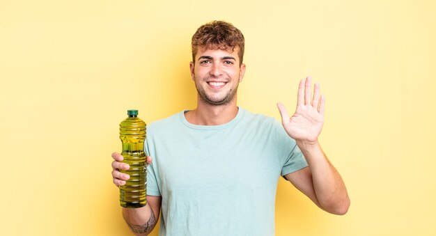 Jovem bonito sorrindo e parecendo amigável, mostrando o número cinco. conceito de azeite