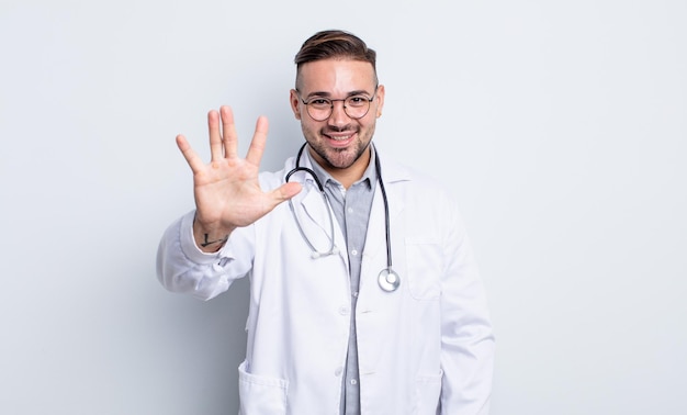 Jovem bonito sorrindo e parecendo amigável, mostrando o número cinco. conceito de médico