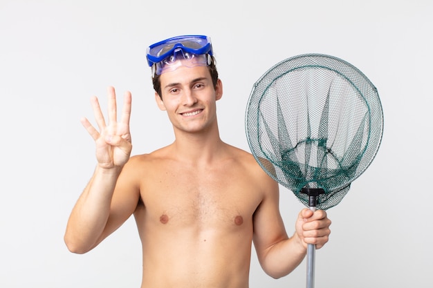 Jovem bonito sorrindo e parecendo amigável, mostrando o número quatro com óculos e uma rede de pesca