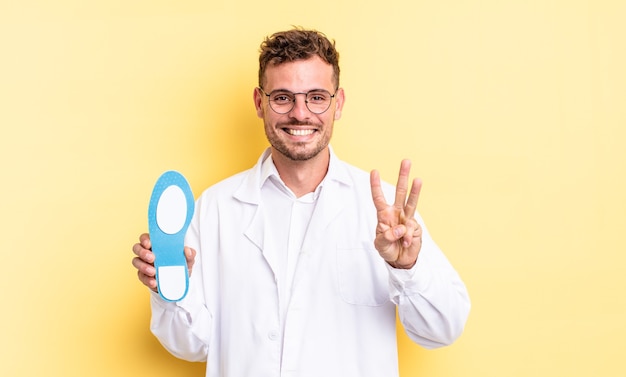 jovem bonito sorrindo e parecendo amigável, mostrando o número três. conceito de quiropodista