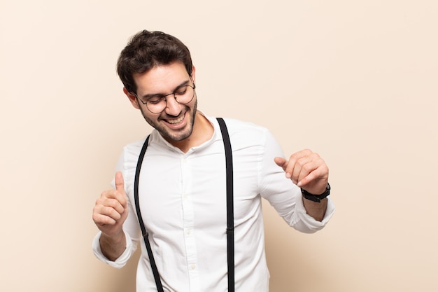 Foto jovem bonito sorrindo, sentindo-se despreocupado, relaxado e feliz, dançando e ouvindo música, se divertindo em uma festa