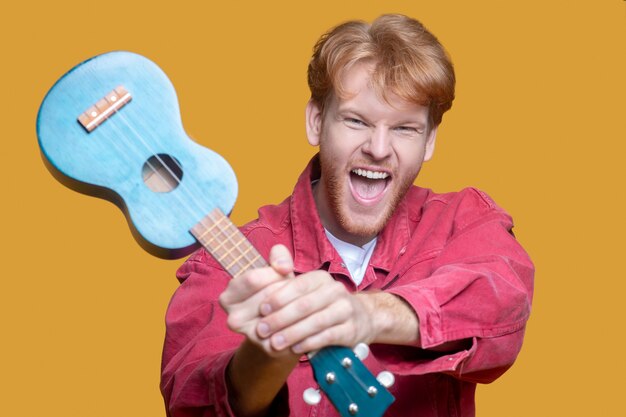 Jovem bonito tocando ukulele