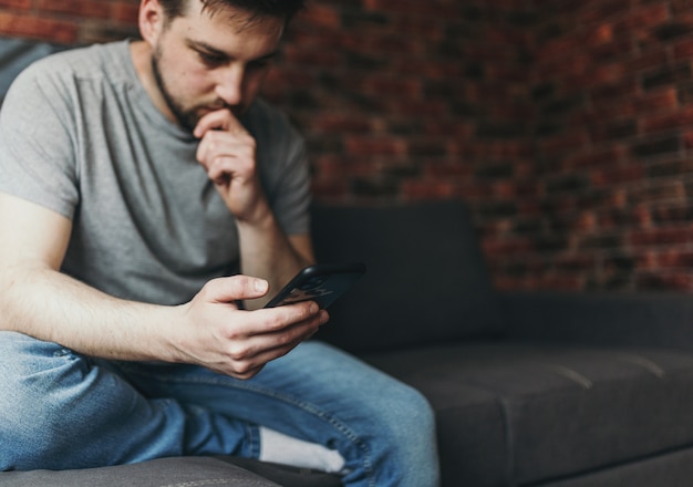 Jovem bonito usando seu smartphone