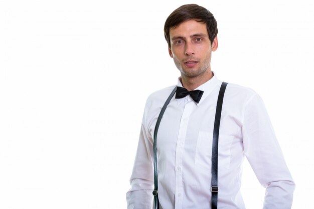 jovem bonito usando suspensórios e gravata borboleta