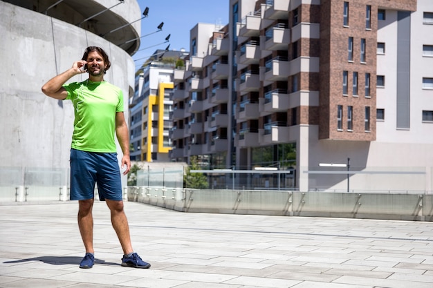 Jovem bonito usando telefone celular durante o exercício