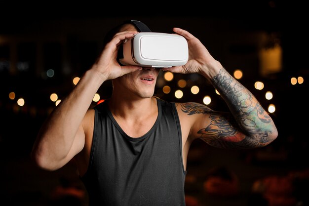 Jovem bonito usando um fone de ouvido da realidade virtual