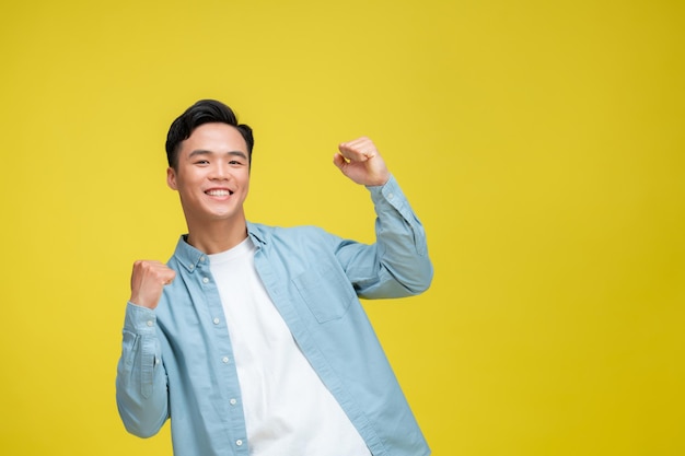 Jovem bonito vestindo roupas casuais gritando orgulhoso celebrando vitória e sucesso muito entusiasmado com os braços levantados