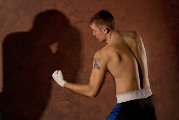 Jovem boxeador em forma lutando no ringue