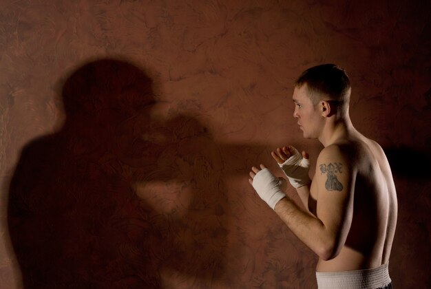 Jovem boxeador observando seu oponente no ringue