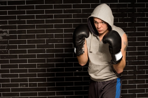 Jovem boxeador treinando para uma luta agachado