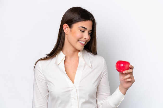 Jovem brasileira com uma maçã isolada no fundo branco com expressão feliz