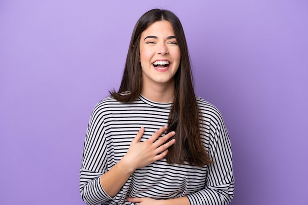 Jovem brasileira isolada em fundo roxo sorrindo muito