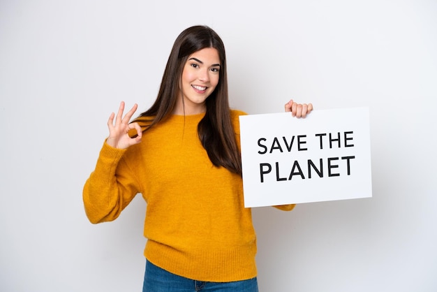 Jovem brasileira isolada no fundo branco segurando um cartaz com texto Salve o Planeta e comemorando uma vitória