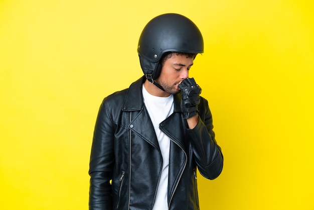 Jovem brasileiro com capacete de moto isolado em fundo amarelo com dúvidas