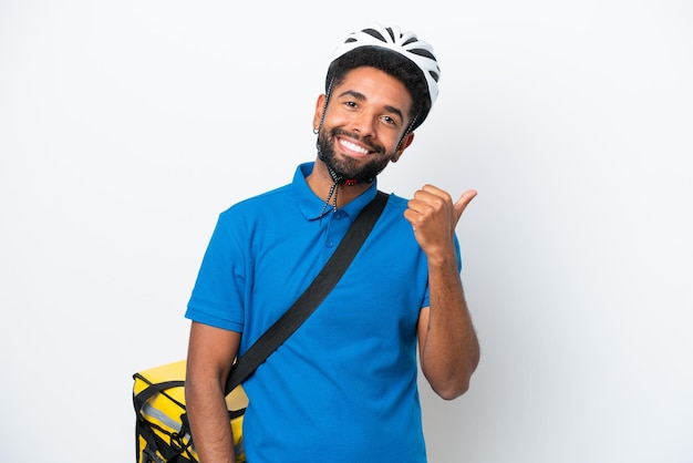 Jovem brasileiro com mochila térmica isolada em fundo branco apontando para o lado para apresentar um produto