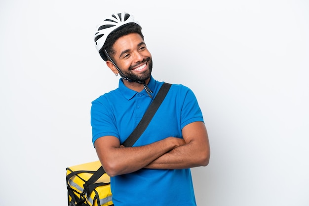 Jovem brasileiro com mochila térmica isolada em fundo branco feliz e sorridente