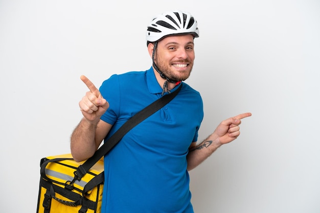 Jovem brasileiro com mochila térmica isolada no fundo branco, apontando o dedo para as laterais e feliz