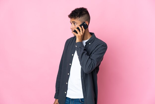 Foto jovem brasileiro de rosa conversando com alguém ao telefone celular