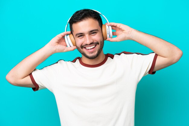 Jovem brasileiro isolado em fundo azul ouvindo música