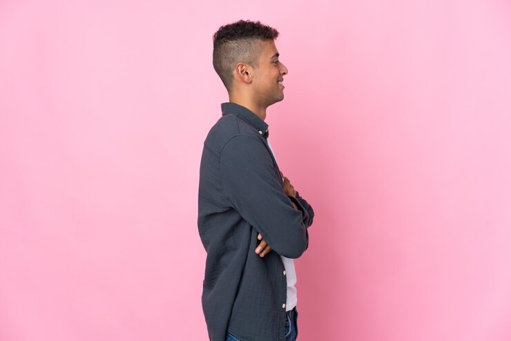 Foto jovem brasileiro isolado em fundo rosa em posição lateral