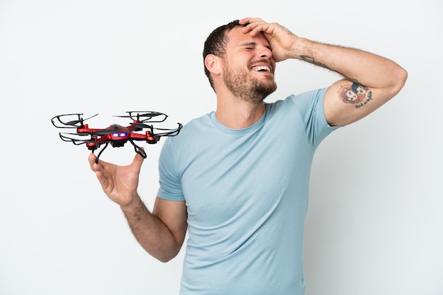 Jovem brasileiro segurando um drone isolado no fundo branco sorrindo muito