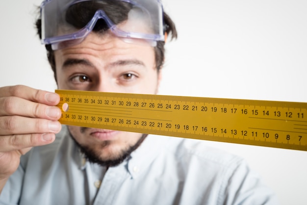 Jovem bricolage trabalhando medindo com medidor