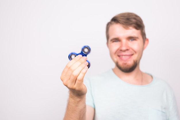 Jovem brincando com um girador de inquietação, foco no girador.