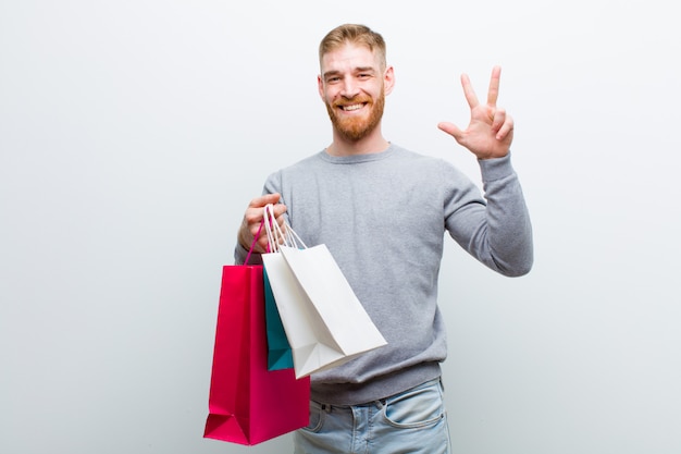 Jovem cabeça vermelha com sacos de compras