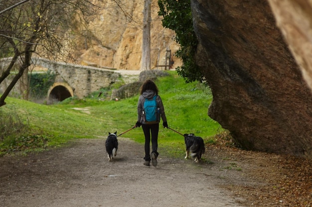 Jovem caminhando com cachorro e passeando no eremitério medieval de Tobera