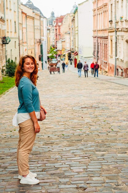 jovem caminhando na antiga cidade europeia edifícios históricos turismo alegria viagens férias Europa