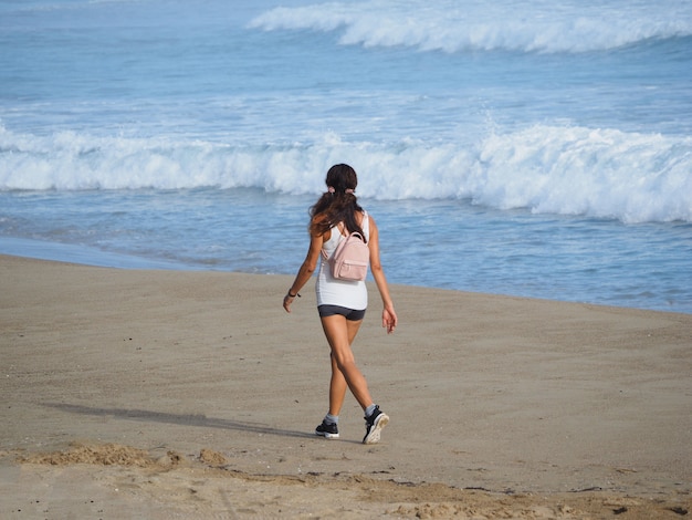 Jovem caminhando na praia