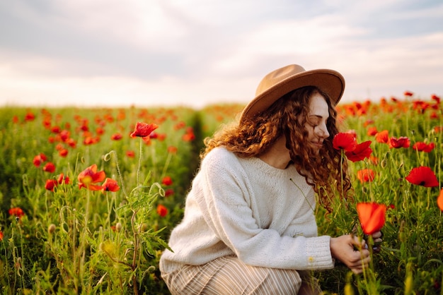 Jovem caminhando no incrível campo de papoulas Férias na natureza relaxam e estilo de vida