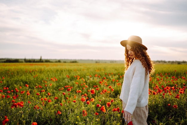 Jovem caminhando no incrível campo de papoulas Férias na natureza relaxam e estilo de vida