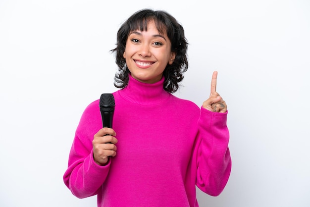 Jovem cantora argentina isolada em fundo branco apontando uma ótima ideia