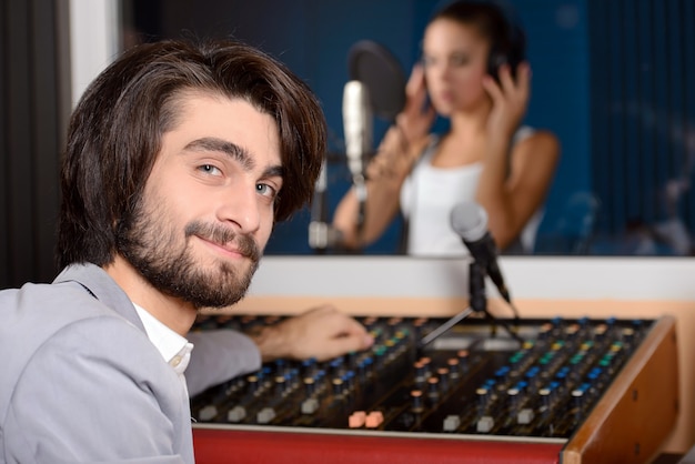 Jovem cantora com técnico de estúdio.