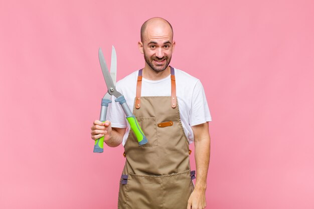 Jovem careca parecendo feliz e agradavelmente surpreso, animado com uma expressão de fascínio e choque