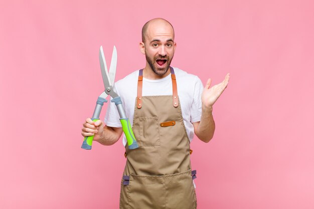 Jovem careca se sentindo feliz, excitado, surpreso ou chocado, sorrindo e surpreso com algo inacreditável