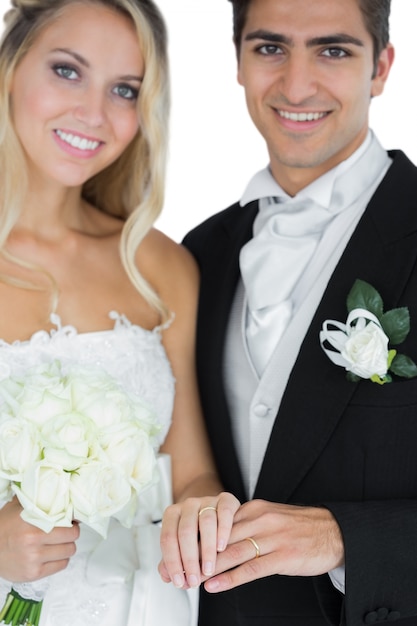 Foto jovem casado posando vestindo anéis de casamento