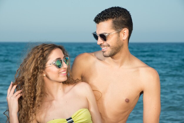 jovem casal à beira-mar, aproveitando o sol na primavera ou verão