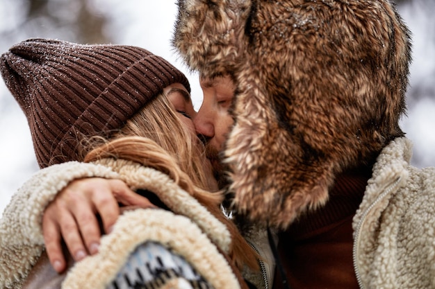 Jovem casal abraçando e beijando no parque no inverno