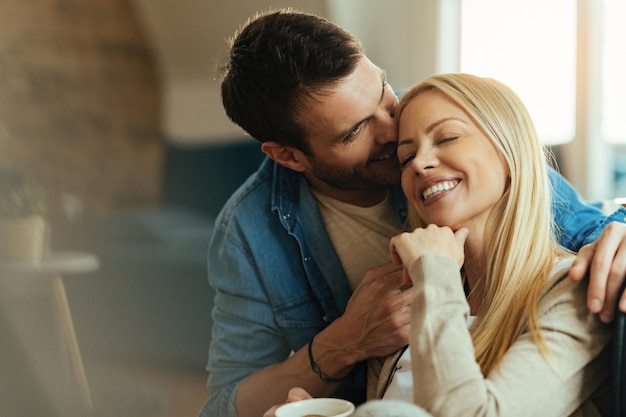 Jovem casal afetuoso desfrutando de seu amor em casa.