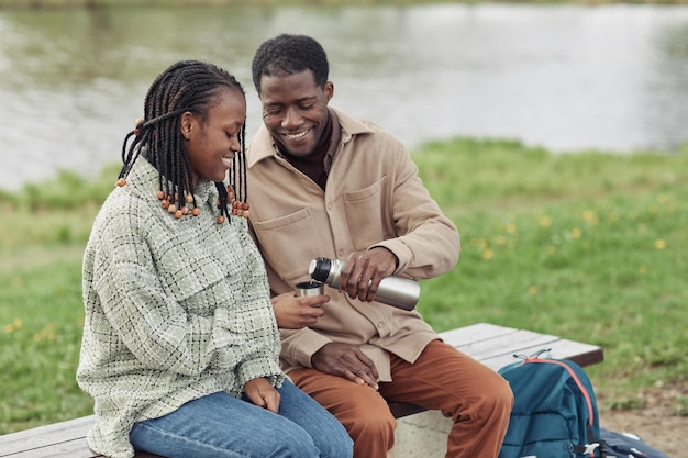 Jovem casal africano bebendo chá ao ar livre