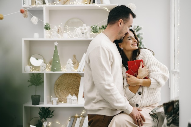 Jovem casal alegre apaixonado por um presente de Natal, retrato