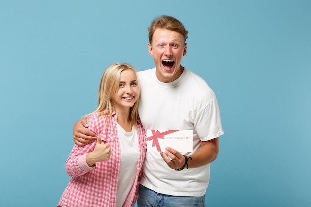 Jovem casal alegre dois amigos cara e mulher em camisetas brancas rosa vazias posando