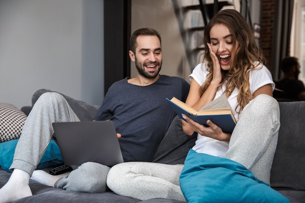 Jovem casal alegre relaxando no sofá em casa