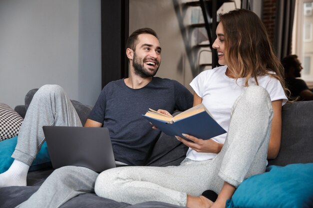 Jovem casal alegre relaxando no sofá em casa