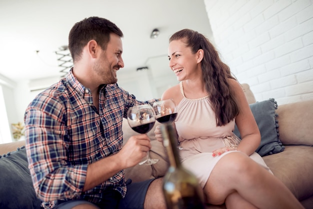 Jovem casal apaixonado bebe vinho tinto