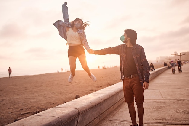 Foto jovem casal apaixonado caminha ao longo da praia durante um belo pôr do sol