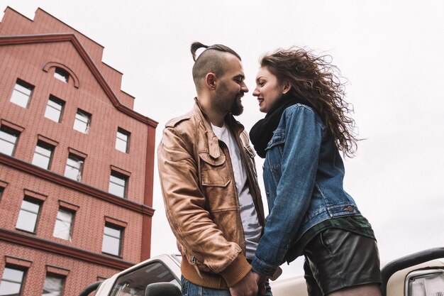 Foto jovem casal apaixonado conversando em pé perto do carro